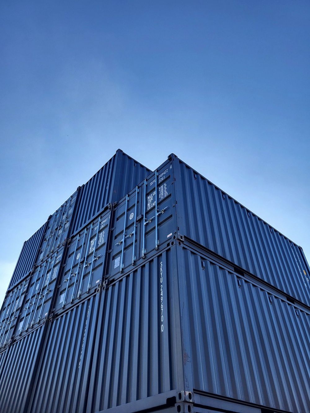 Shipping containers stacked against a clear sky