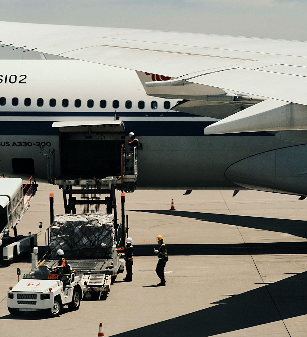 Ground crew loading a cargo pallet into an aircraft hold