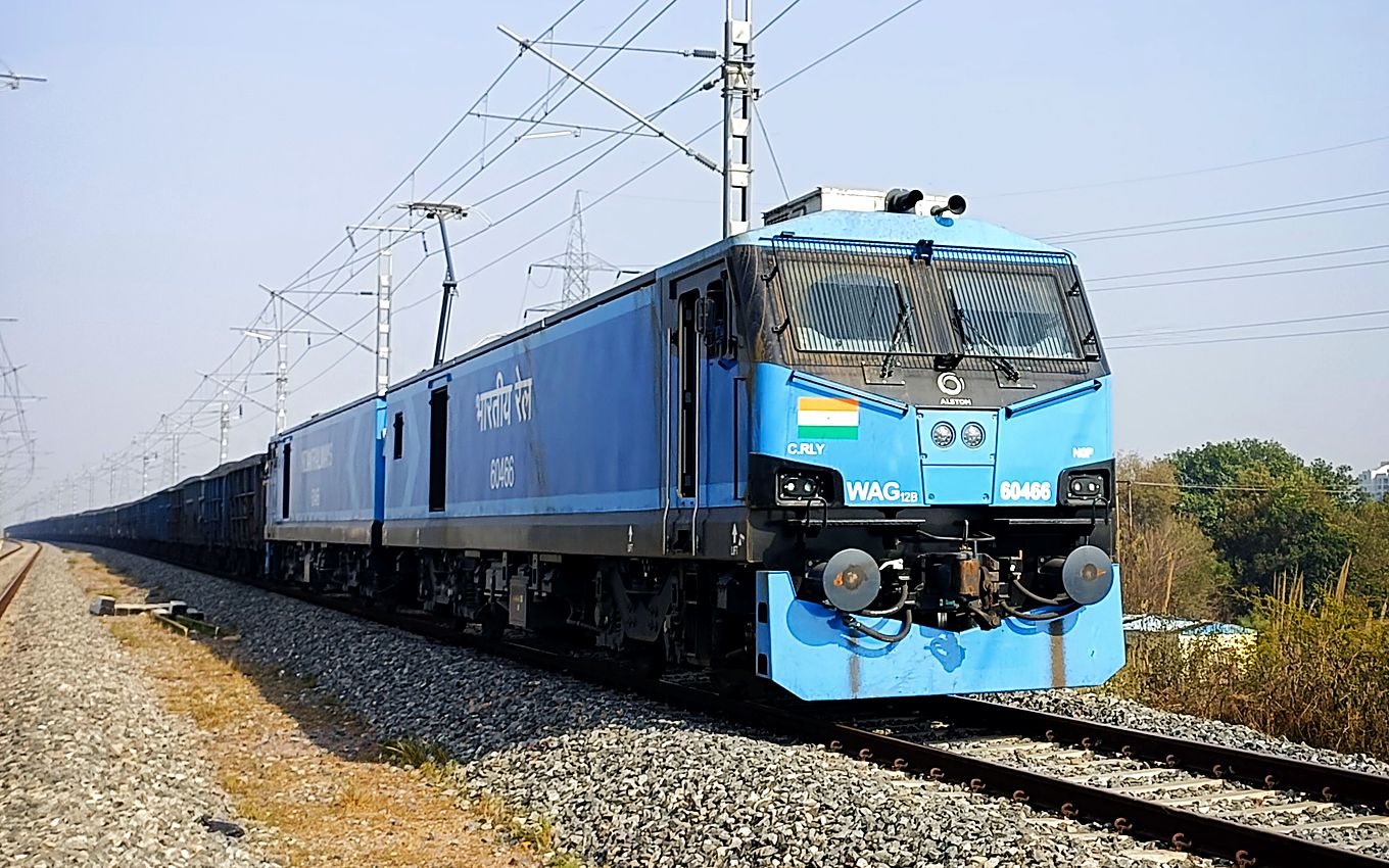 An Indian Railways electric locomotive hauling a loaded freight rake