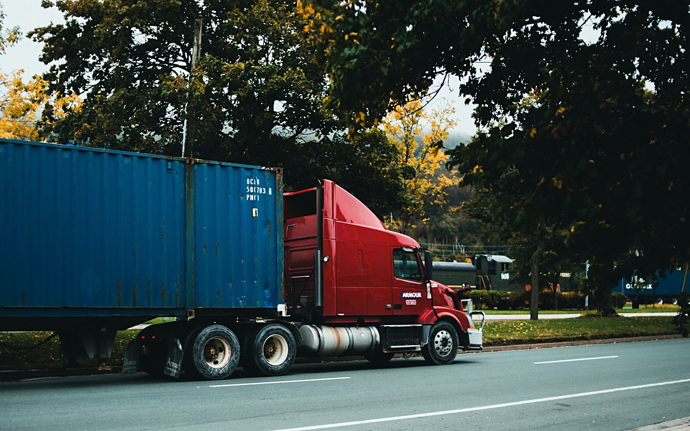 A shipping container on an articulated trailer moving on the highway